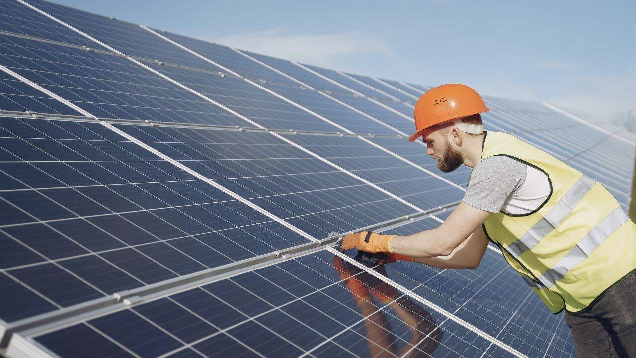 un lucrator care instaleaza panouri solare