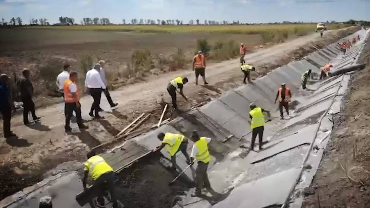 mai multe persoane pe un canal de irigatii